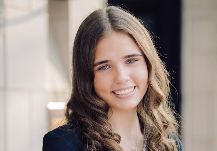 Allison Willner headshot long brown curly hair.